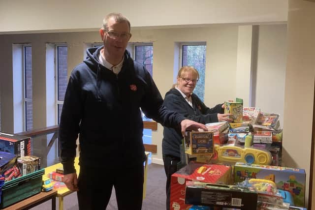 Majors Mark and Alison Lewis receiving gifts for The Salvation Army to redistribute to children at Christmas