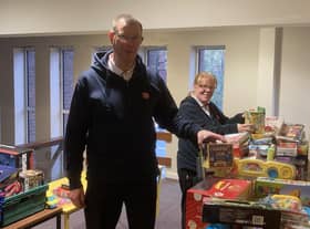 Majors Mark and Alison Lewis receiving gifts for The Salvation Army to redistribute to children at Christmas
