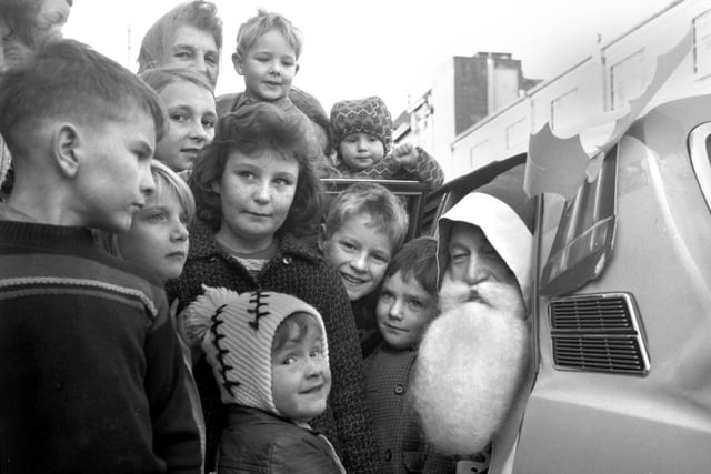 Father Christmas is greeted by children as he arrives at Oxleys store on Station Road, Wigan, in 1971.