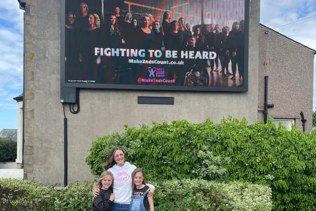 (From left) Nancy, Kate, and Ruby in front of the Morecambe billboard