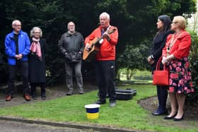 Musician Lawrence Hoy performs at the 10th annual Workers' Memorial Day, with a ceremony around the memorial tree and plaque in Mesnes Park, Wigan.