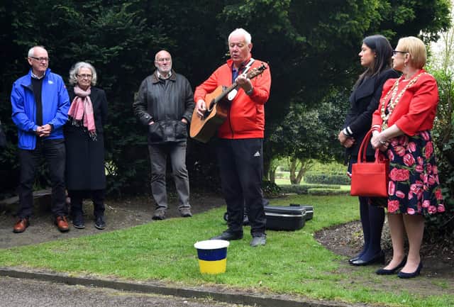 Musician Lawrence Hoy performs at the 10th annual Workers' Memorial Day, with a ceremony around the memorial tree and plaque in Mesnes Park, Wigan.