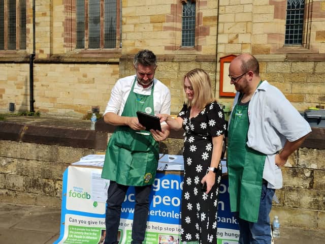 Project director Warren Done, former Leigh MP Jo Platt, and volunteer Paul Blinkhorn at the stall