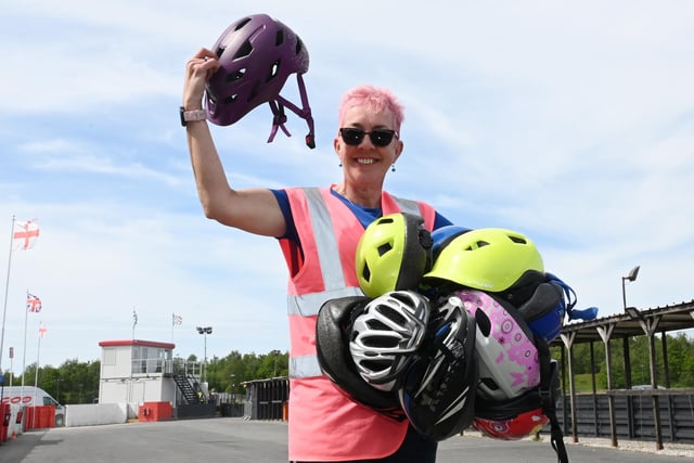 Joy Lummis handing out cycle helmets to riders.