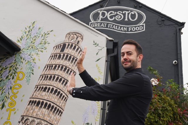 James Lavin, head of marketing at Pesto with the a mural of the Leaning Tower of Piza, encourages customers to do fun selfies with the mural.