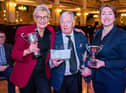 Band manager Norma Tinsley (left) accepting the award from competition adjudicators Alan Widdop and Stephanie Binns