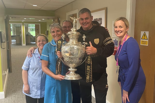 Derek Beaumont, owner of Leigh Leopards, shows the Challenge Cup trophy to hospice staff