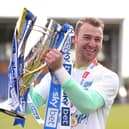 Jamie Jones celebrates with the League One trophy at Shrewsbury in 2022
