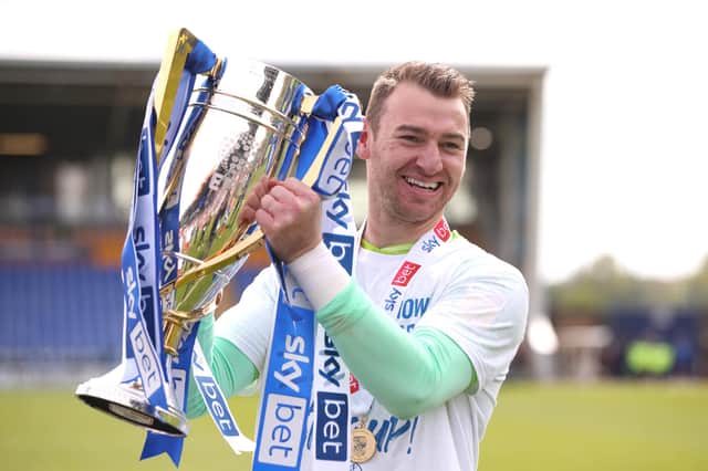 Jamie Jones celebrates with the League One trophy at Shrewsbury in 2022