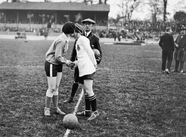 The captains of the French and English Ladies football teams, Carmen Pomies (left) and Florrie Redford, having a handshake and a peck on the cheek before the start of the England vs France Women's International Football match in aid of shipwrecked mariners, at Herne Hill, London, 12th May 1925. (Photo by MacGregor/Topical Press Agency/Hulton Archive/Getty Images)