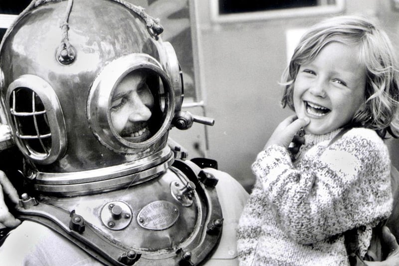 Lisa Walker, aged 5, from Blackrod, has a surprise encounter with Sgt. John Fairclough of the Police Underwater Search Unit at the National Waterways rally at Wigan Pier on bank holiday Monday 29th of August 1983.