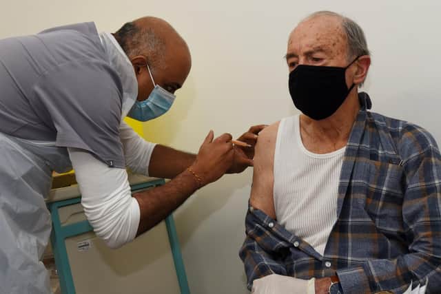 Pensioner Allan Williams gets his first vaccine by pharmacist Sunil Patel  at Hollowood Vaccination Centre, Mesnes Street in January 2021