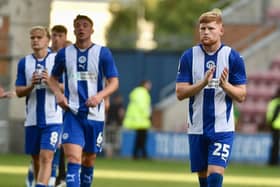 Charlie Hughes (second right) applauds the Latics fans after Saturday's home defeat to Charlton