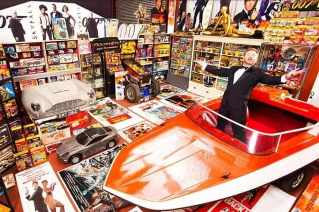 An appropriately dressed Nick Bennett pictured with his vast hoard of Bond memorabilia at the time of his Guinness Book of World Records listing in 2014