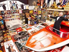 An appropriately dressed Nick Bennett pictured with his vast hoard of Bond memorabilia at the time of his Guinness Book of World Records listing in 2014