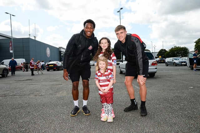 Junior Nsemba and Harvie Hill pose for a photo with two young fans
