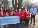 Councillors Laura Flynn and Chris Ready hand over a cheque to school council members