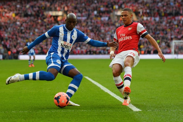 Marc-Antoine Fortune crosses the ball under pressure from Kieran Gibb during the FA Cup Semi-Final match between Wigan Athletic and Arsenal at Wembley Stadium on April 12, 2014 in London, England.