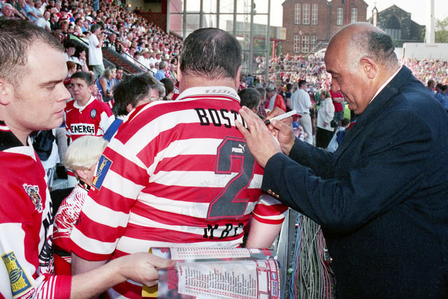Wigan legend Billy Boston signs autographs for fans prior to kick off against St. Helens.