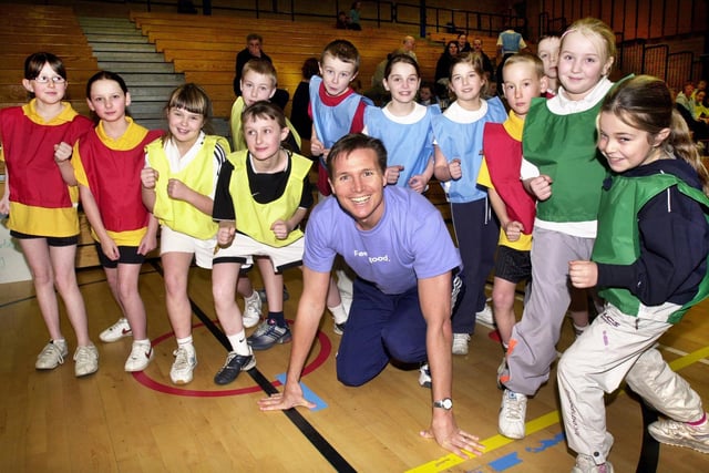 Olympic silver medallist and 400m champion, Roger Black, ready for the start of the primary schools indoor athletics competition at Robin Park with pupils from St. Aidans, St. Judes, Beech Hill and Pemberton Primary Schools.   He was visiting Wigan to promote an exercise programme for over 50s and present awards for Wigan Council on Friday 16th of January 2004 on the same day that London unveiled plans for its bid for the 2012 Olympic games.