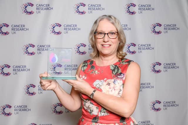 Carolyn Cross with her award from Cancer Research UK