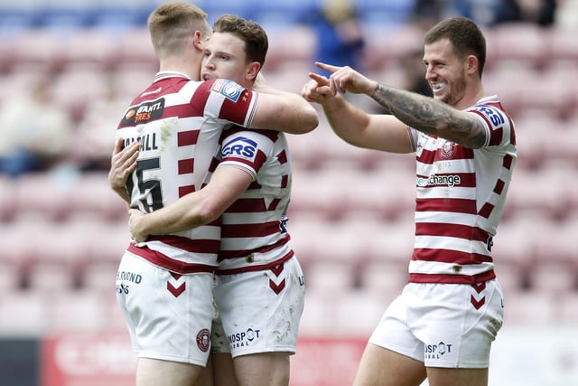 Sam Halsall, Jai Field and Cade Cust all celebrates Wigan's seventh try of the afternoon.