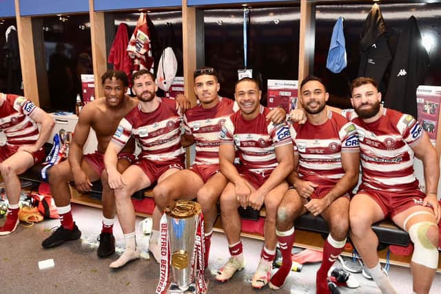 Wigan Warriors players with the Super League trophy inside the Old Trafford changing rooms