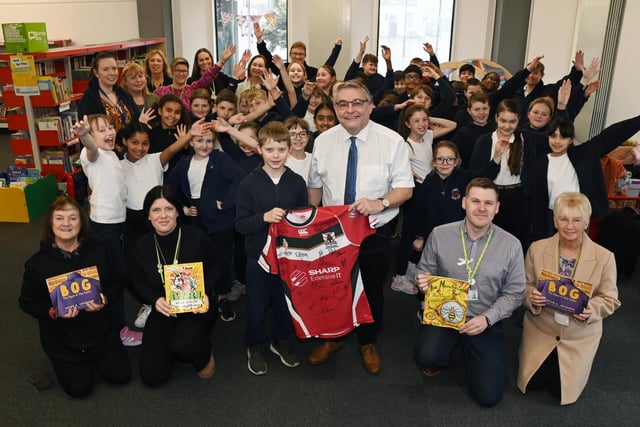 Coun Chris Ready, centre, with other councillors present the signed rugby shirt to Year Five pupil Wilson, accepting it for the school, also books were donated to the school.