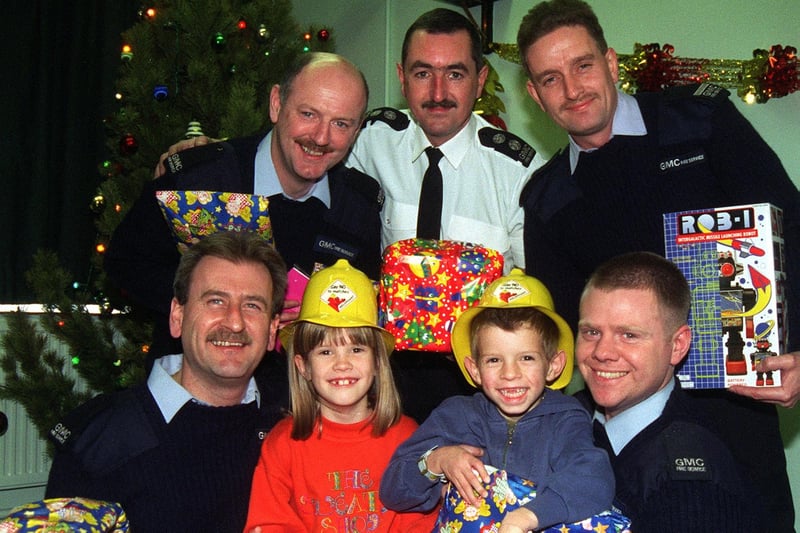 Nicola, eight, and Jamie Jones, five, who had their Christmas ruined when their presents caught fire pictured with firefighters from Blue Watch Wigan, who rallied round with the help of local stores who included Asda  British Home Stores and John Menzies who donated toys and gifts for the youngsters. The  firemen are, from left,  Geoff Fazackerley, Jim Webster  Neil Constantine   Howard Yates and Joe Steven.