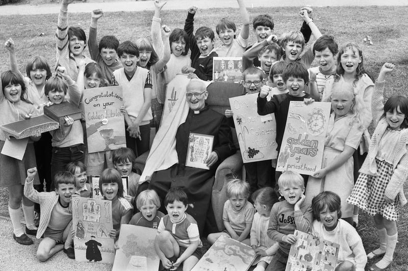 Parish priest of St. Patrick's RC Church, Scholes, Father James Lappin is presented with cards and gifts by schoolchildren on his Golden Jubilee in June 1983.