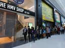 Excited shoppers queue outside the shop for the opening of The HMV Shop, Grand Arcade, Wigan