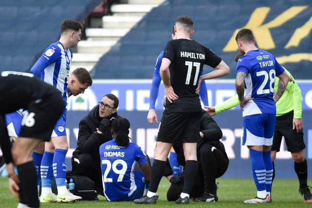 Silko Thomas receives lengthy treatment before being stretchered off against Lincoln