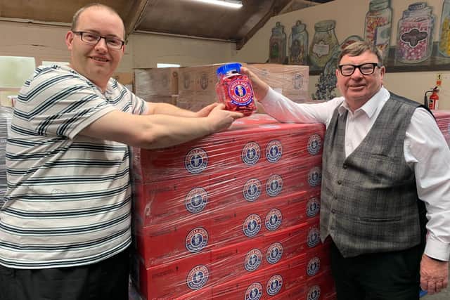 Chris Winnard (left) accepts a jar of Uncle Joe's Mint Balls from John Winnard (no relation) at the Wm Santus and Co factory in gratitude for his cheery new song about the company