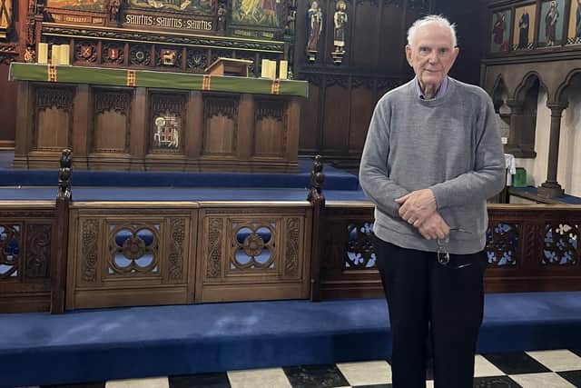 John Collier pictured by the font where he was christened in St Andrew's church, Wigan