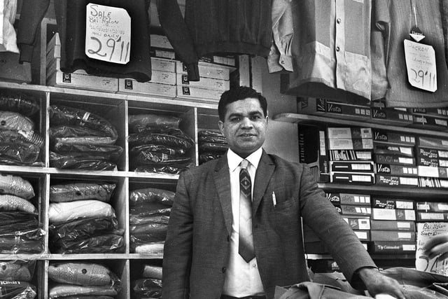 Menswear stall holder Ali Khan in the Old Arcade, Wigan, in the early 1970s.