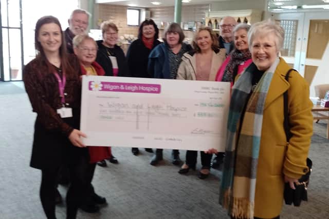 Voices in Harmony members hand over their cheque to Wigan and Leigh Hospice