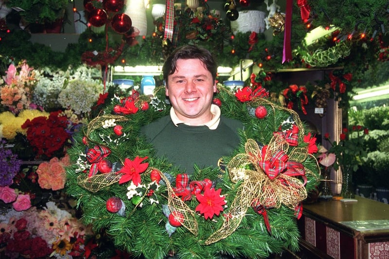 Adam Hill  inside his florists shop  festooned with Christmas  floral decor.