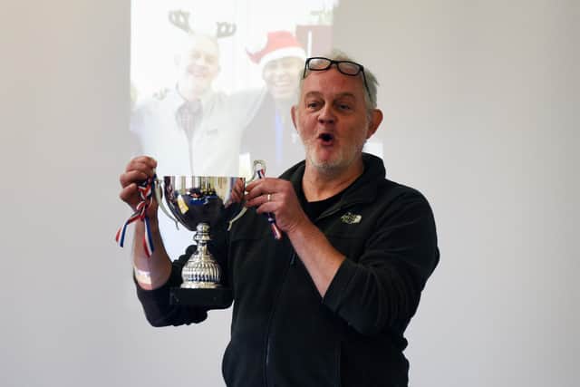 Mick Taylor, who is project co-ordinator at SWAP, holding up a football trophy won by a refugees' team which was assembled by Kunil Nur.