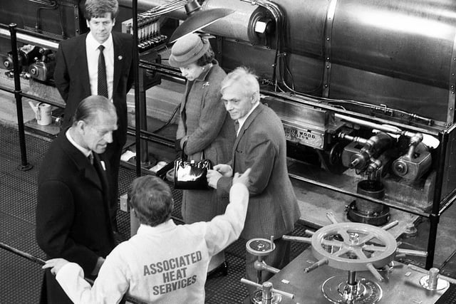 The Duke of Edinburgh hears all the secrets of the Trencherfield Mill engine from engineer Ted Melling as the Queen peers at something else of interest. Looking on are Council leader Bernard Coyle and Assistant Planning Officer Alan Wenham on the occasion of the Queen's opening of Wigan Pier on Friday 21st of March 1986.