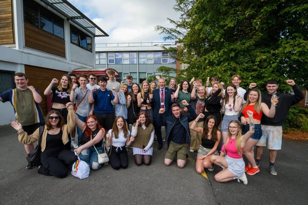Students celebrate with principal Peter McGhee CBE
