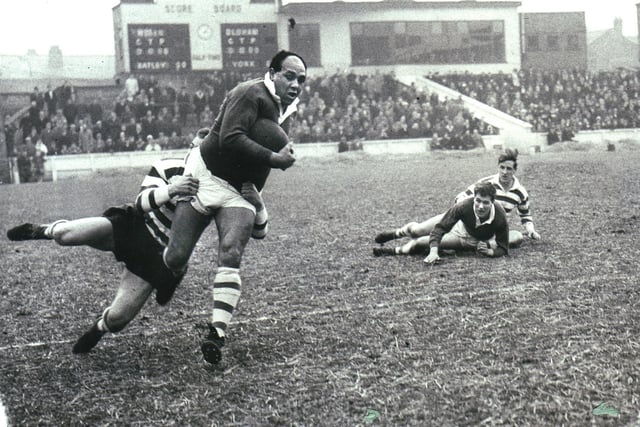 Billy Boston in typical action on the wing after taking a pass from the grounded Eric Ashton in the match against Oldham in 1965.