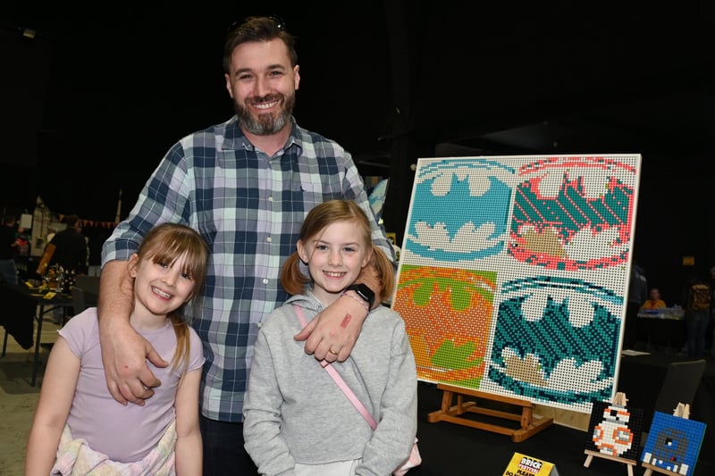 BLACKPOOL - 08-04-23 Lego fans enjoyed workshops, games, stalls and displays at Blackpool Brick Festival, held at the Winter Gardens, Blackpool. Peter Bailey with Eliza, eight, left, and Scarlett, ten, enjoy the Lego artwork.