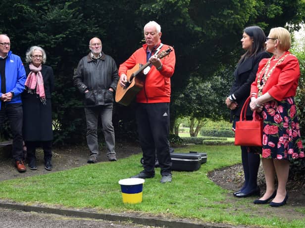 Musician Lawrence Hoy performing to close last year's Workers' Memorial Day ceremony around the memorial tree and plaque in Mesnes Park, Wigan.