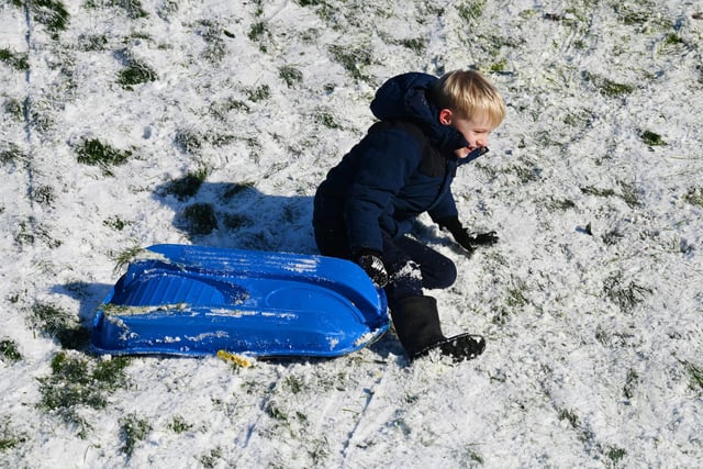 Wigan snow scenes - People make the most of the winter weather as snow falls on Mesnes Park, Wigan.