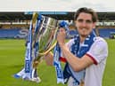 Tom Bayliss celebrates with the League One title