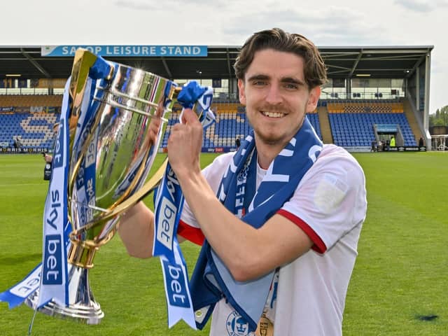 Tom Bayliss celebrates with the League One title