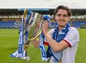 Tom Bayliss celebrates with the League One title