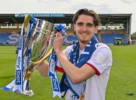 Tom Bayliss celebrates with the League One title