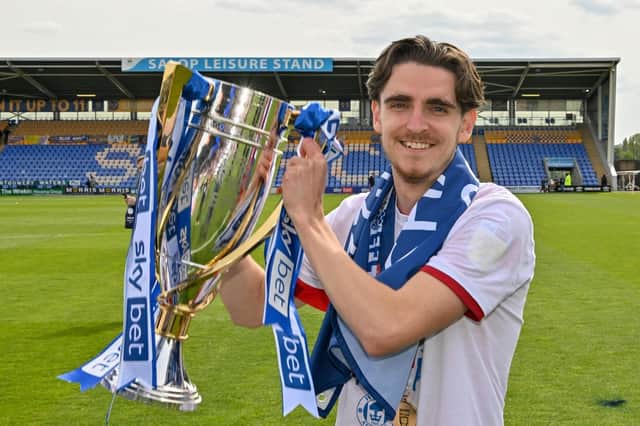 Tom Bayliss celebrates with the League One title