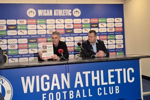 Ryan Lowe holds up an appeal poster for missing Darren Orme during his maiden press conference as Latics head coach